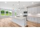 Bright, open kitchen featuring white cabinets, stainless steel appliances, and an island with a sink and quartz countertop at 4896 Grosbeak Ct, Mebane, NC 27302
