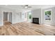 Well-lit living room featuring hardwood floors, a cozy fireplace, custom built-ins, and large, bright windows at 4896 Grosbeak Ct, Mebane, NC 27302
