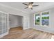 Sunlit living room with light wood floors, French doors, and large windows offering scenic views at 4896 Grosbeak Ct, Mebane, NC 27302