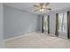 Neutral bedroom with carpet floors, two windows with curtains, and a ceiling fan for added comfort at 5109 Makena Dr, Raleigh, NC 27615