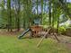 A backyard wooden playground with a slide and swings provides outdoor recreation and fun for children at 5109 Makena Dr, Raleigh, NC 27615