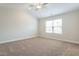 Bedroom with neutral carpeting, base trim, large window, and ceiling fan providing a comfortable space at 5330 River Reach Dr, Raleigh, NC 27616