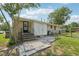 The backyard has a brick exterior with steps leading to a door, partial fencing, and green grass at 555 Dacian Rd, Raleigh, NC 27610