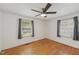 This bright bedroom has two large windows, hardwood floors and a ceiling fan at 555 Dacian Rd, Raleigh, NC 27610