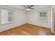 This bright bedroom has two large windows, hardwood floors and a ceiling fan at 555 Dacian Rd, Raleigh, NC 27610
