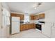 Functional kitchen with wooden cabinets and white appliances, including a washer and dryer for convenience at 555 Dacian Rd, Raleigh, NC 27610