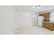 Bright kitchen with white tile flooring, wooden cabinets, and white appliances for modern living at 555 Dacian Rd, Raleigh, NC 27610