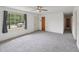 Bright living room featuring new carpeting, a ceiling fan, and a large window providing ample natural light at 555 Dacian Rd, Raleigh, NC 27610