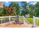 Wooden back deck with white railings and seating area, overlooking a lush backyard at 59 Carrousel Ct, Angier, NC 27501