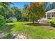 Expansive backyard featuring mature trees, green grass, a deck, and a storage shed at 59 Carrousel Ct, Angier, NC 27501