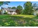 Spacious backyard with lush lawn, mature trees, and patio area at 59 Carrousel Ct, Angier, NC 27501