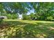 Large grassy backyard surrounded by mature trees and neighborhood homes at 59 Carrousel Ct, Angier, NC 27501