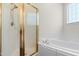 Bathroom with a glass-enclosed shower and a separate jacuzzi tub under a window with frosted glass at 59 Carrousel Ct, Angier, NC 27501