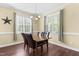 Dining room with a chandelier, natural light from two windows, and a dark wood table with upholstered chairs at 59 Carrousel Ct, Angier, NC 27501