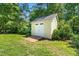 Well maintained backyard storage shed featuring a wood ramp and painted double door at 59 Carrousel Ct, Angier, NC 27501