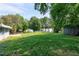 Large backyard offering green space and privacy, surrounded by mature trees on a sunny day at 603 Nellane Dr, Garner, NC 27529