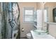 Bathroom with clear vessel sink, floral shower curtain and white cabinets at 603 Nellane Dr, Garner, NC 27529
