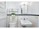 Bathroom featuring white tile walls, open shelving and a vintage sink at 603 Nellane Dr, Garner, NC 27529