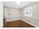 A light-filled bedroom with neutral walls, hardwood floors and a window at 603 Nellane Dr, Garner, NC 27529