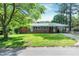 Charming brick home featuring a well-manicured lawn, mature trees, and an inviting covered front porch at 603 Nellane Dr, Garner, NC 27529