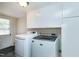 Laundry room featuring a washer and dryer, plus white cabinets and an exit door at 603 Nellane Dr, Garner, NC 27529