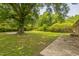 A spacious backyard with mature trees and large manicured lawn at 605 Sexton Ave, Zebulon, NC 27597