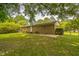 Exterior view of a brick home with a spacious backyard, mature trees, and a patio at 605 Sexton Ave, Zebulon, NC 27597