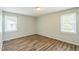 Bedroom featuring new wood floors and two bright windows with natural light at 605 Sexton Ave, Zebulon, NC 27597