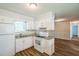 Bright kitchen with white cabinets, updated appliances, and an open layout to the living room at 605 Sexton Ave, Zebulon, NC 27597