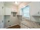 The laundry room features storage cabinets, granite countertop, and bright natural light at 605 Sexton Ave, Zebulon, NC 27597
