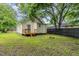 View of the home's backyard featuring a grassy lawn, wood deck, and tan-colored siding at 611 Rowland St, Henderson, NC 27536