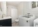 Updated bathroom with shiplap walls, modern vanity, and shower with white curtain, and laundry at 611 Rowland St, Henderson, NC 27536