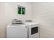 Bright laundry room with shiplap walls and modern, white appliances at 611 Rowland St, Henderson, NC 27536