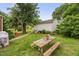 Backyard with picnic table, grass, detached garage, and mature shade tree at 625 Columbia Ave, Burlington, NC 27217