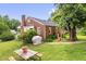 Backyard of brick home with grill, trees, grass, and picnic table at 625 Columbia Ave, Burlington, NC 27217