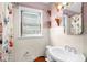Cozy bathroom with ceramic tile, a window, and a modern sink with a vintage mirror and decorative shelving at 625 Columbia Ave, Burlington, NC 27217
