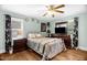 Cozy bedroom featuring wood floors, ceiling fan, and well-lit with natural light from two windows at 625 Columbia Ave, Burlington, NC 27217