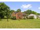 Quaint brick home with a covered front porch, showcasing a well-kept lawn and mature trees in a serene setting at 625 Columbia Ave, Burlington, NC 27217