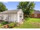 Detached garage with shingled roof and vinyl siding with various plants at 625 Columbia Ave, Burlington, NC 27217
