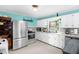 Eat-in kitchen boasts blue walls, white cabinets, stainless steel appliances, and retro aesthetic at 625 Columbia Ave, Burlington, NC 27217