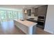 Modern kitchen boasts gray cabinets, stainless appliances, quartz counters, and hardwood flooring at 691 Bandon Aly, Cary, NC 27513