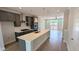 Contemporary kitchen featuring gray cabinetry, stainless appliances, an island with quartz countertops, and hardwood flooring at 691 Bandon Aly, Cary, NC 27513