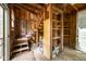 Unfinished attic space featuring exposed wood framing, built-in shelves, and access stairs at 708 October Woods Rd, Chapel Hill, NC 27516