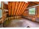 Attic space featuring exposed beams, shelving, and a window at 708 October Woods Rd, Chapel Hill, NC 27516