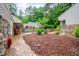 View of a home's charming backyard with stone patio and rock and mulch landscaping at 708 October Woods Rd, Chapel Hill, NC 27516