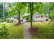Backyard with pathway with the home, deck, and lush trees at 708 October Woods Rd, Chapel Hill, NC 27516