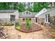 View of a home's charming backyard with stone patio and rock and mulch landscaping at 708 October Woods Rd, Chapel Hill, NC 27516