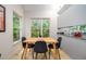 Eat-in dining area with modern table, black chairs, and views of the lush landscape at 708 October Woods Rd, Chapel Hill, NC 27516