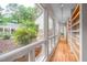 Bright hallway with wood floors, built-in shelves, and large windows to the garden at 708 October Woods Rd, Chapel Hill, NC 27516