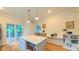 Open kitchen with an island, stainless steel appliances, hardwood floors, and easy deck access at 729 Lorentello Cir, Hillsborough, NC 27278